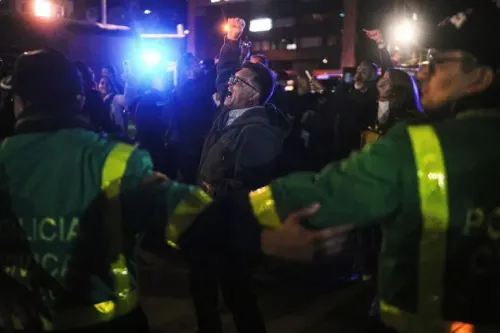 تجمع حشود من الناس في بوغوتا، بينما يتفاعل رجال الشرطة مع المحتجين في أعقاب حادث إطلاق النار على المرشح الرئاسي ميغيل أوريبي.