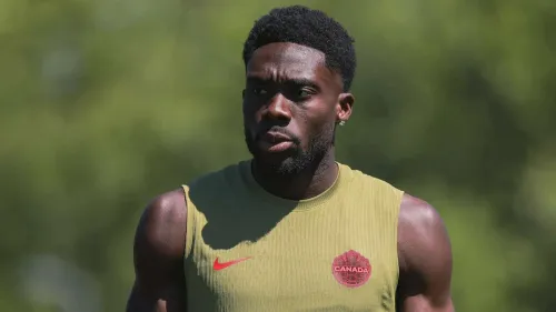 ألفونسو ديفيز لاعب كرة قدم كندي يرتدي زي تدريب المنتخب الكندي، يظهر في صورة خارجية خلال استعدادات كأس العالم لمنطقة CONCACAF.