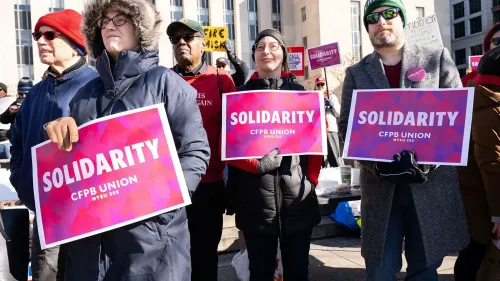 احتجاج لموظفي مكتب الحماية المالية للمستهلكين، حيث يحمل المشاركون لافتات تضامن مكتوب عليها "SOLIDARITY" مع تأكيد على دعمهم للوكالة.