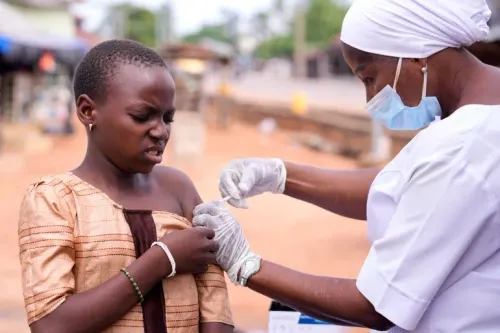 فتاة صغيرة تتلقى لقاح فيروس الورم الحليمي البشري (HPV) من ممرضة في موقع تطعيم، مما يعكس جهود الوقاية من سرطان عنق الرحم.
