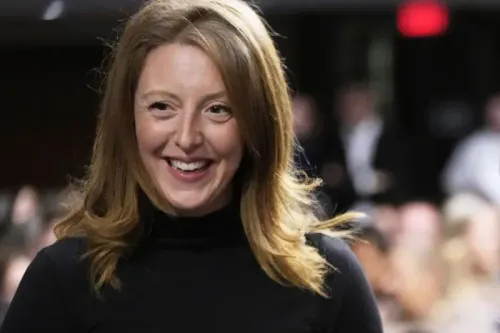 امرأة مبتسمة ترتدي سترة سوداء، تتحدث في قاعة احتفالات فندق ويلارد إنتركونتيننتال، حيث يجتمع مؤثرون في مجال الصحة والغذاء.