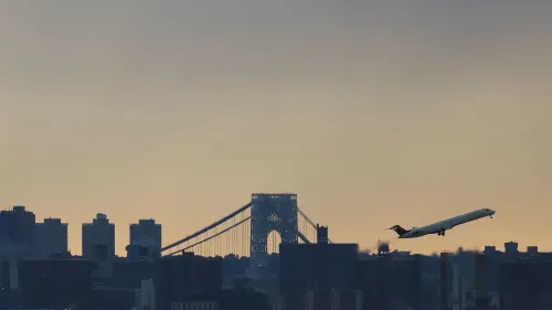 طائرة صغيرة تقلع فوق أفق مدينة نيويورك مع جسر جورج واشنطن في الخلفية، مما يعكس تأثير انقطاع نظام الإشعارات على الرحلات الجوية.