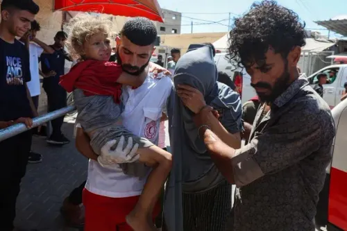 أشخاص يحملون طفلاً مصاباً في غزة، يعكس الوضع الإنساني المتدهور بسبب نقص الوقود والاعتداءات المستمرة.