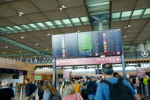 ازدحام في مطار مع شاشات عرض توضح معلومات الرحلات، وسط تأثير هجوم إلكتروني على أنظمة تسجيل الوصول في عدة مطارات أوروبية.