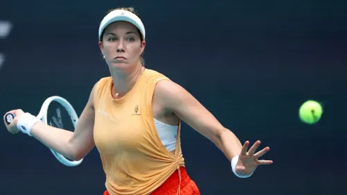 دانييل كولينز، لاعبة تنس أمريكية، تضرب كرة التنس أثناء مباراة في بطولة ميامي المفتوحة، مع تعبير جاد على وجهها.