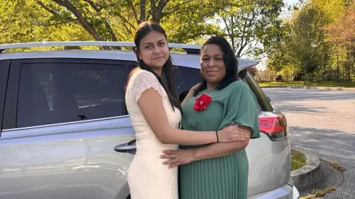 امرأة وابنتها تتعانقان أمام سيارة في مكان مفتوح، مع خلفية طبيعية، تعكس لحظة عاطفية في سياق قضيتهما القانونية.