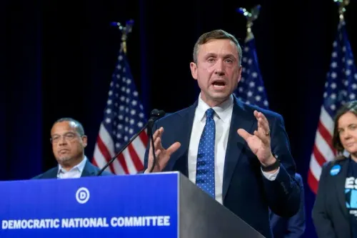 كين مارتن، رئيس اللجنة الوطنية الديمقراطية، يتحدث خلال مؤتمر صحفي، مع أعضاء آخرين في الخلفية، أمام لافتة الحزب.