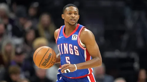 دي آرون فوكس، حارس فريق ساكرامنتو كينجز، يحمل كرة سلة، مع التركيز على انتقاله المحتمل إلى سان أنطونيو سبيرز.