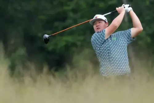 لاعب جولف يضرب الكرة في ملعب أوكمونت، محاط بالعشب الطويل. يُظهر التركيز والتحدي في بطولة الولايات المتحدة المفتوحة.