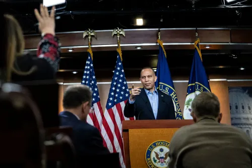 زعيم الأقلية في مجلس النواب حكيم جيفريز يتحدث خلال مؤتمر صحفي، مع وجود أعلام أمريكية خلفه.