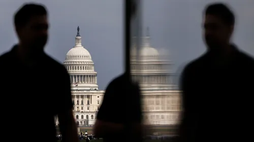 صورة توضح مبنى الكابيتول الأمريكي مع silhouettes لأشخاص في المقدمة، تعكس التوترات السياسية التي يواجهها الديمقراطيون في انتخابات مجلس الشيوخ.