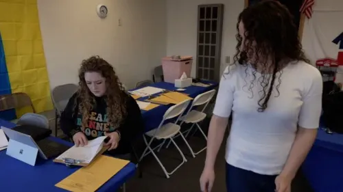 محتجون ديمقراطيون يعملون في مكتب انتخابي، مع تكدس مستندات وأدوات على الطاولة، يعكسون جهود الحزب لمواجهة تحديات ترامب.