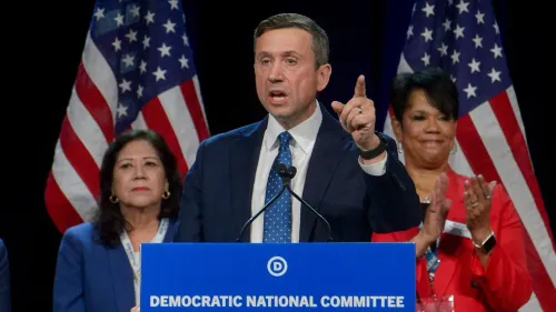 كين مارتن يتحدث أمام حشد بعد انتخابه رئيسًا للجنة الوطنية الديمقراطية، مع أعلام أمريكية في الخلفية، مؤكدًا التزامه بتعزيز الحزب.