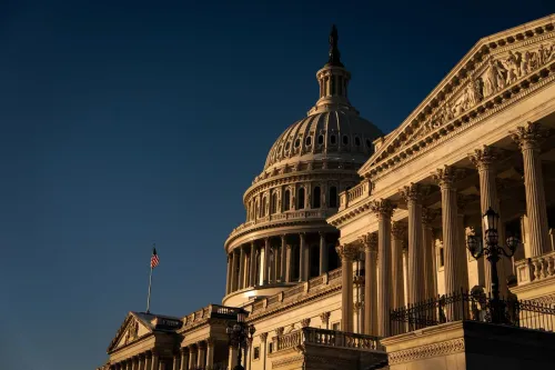 مبنى الكابيتول الأمريكي تحت أشعة الشمس، مع تفاصيل معمارية بارزة، يمثل مركزًا للقرارات السياسية حول تمويل الحكومة.