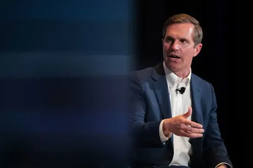 حاكم كنتاكي آندي بيشير يتحدث في مؤتمر، معبرًا عن قلقه بشأن تأثير قانون ترامب على برنامج Medicaid والطبقة العاملة.