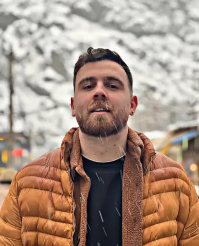 عرفان سلطاني، المتظاهر الإيراني المحتجز، يظهر في صورة أثناء تساقط الثلوج، مع خلفية جبلية، ويبدو في صحة جيدة.