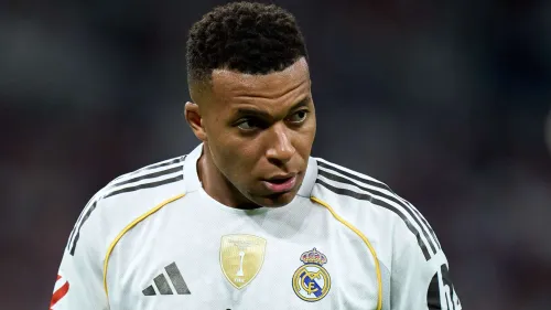 كيليان مبابي لاعب ريال مدريد يرتدي قميص الفريق الأبيض خلال مباراة، مع التركيز على تحدياته في الفوز بدوري أبطال أوروبا وجائزة الكرة الذهبية.