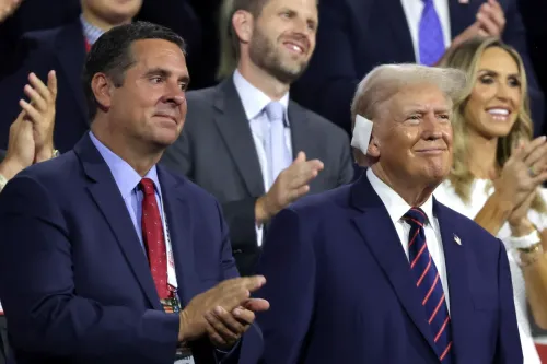 Devin Nunes يقف بجانب دونالد ترامب في حدث عام، حيث يعبر ترامب عن سعادته وسط تصفيق الحضور، مع التركيز على التغييرات في قيادة Trump Media.