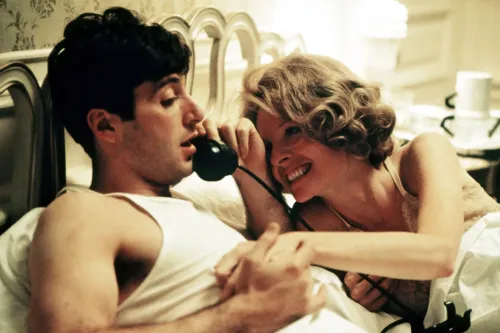 ديان كيتون تتحدث مع شخصية في مشهد من فيلم "العراب"، حيث يظهر تعبيرها المميز وأسلوبها الكوميدي الفريد.