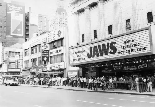 طابور طويل من الناس أمام دار عرض فيلم "الفك المفترس"، مع لافتة كبيرة تعلن عن الفيلم كـ"فيلم رعب مرعب".