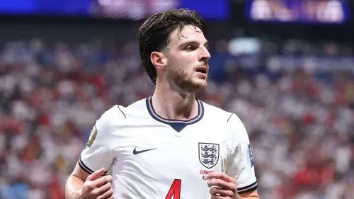 لاعب خط وسط منتخب إنجلترا Declan Rice يرتدي قميص الفريق الأبيض خلال مباراة في استاد أزتيكا، مع خلفية جماهيرية مشجعة.