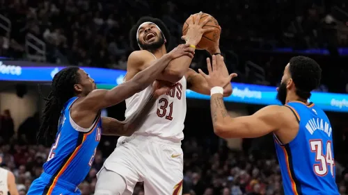 مشهد من مباراة كرة السلة حيث يتنافس لاعبون للحصول على الكرة، مع التركيز على لحظة حماسية في اللعب.