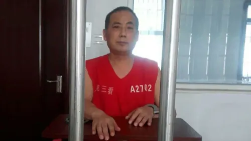 رجل مسن يرتدي سترة حمراء، يجلس خلف قضبان، مع تعبير هادئ، يمثل قصة نضال من أجل الحرية واللجوء في كوريا الجنوبية.
