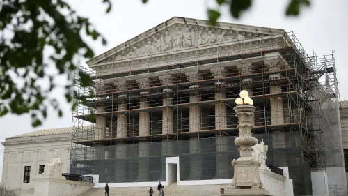 واجهة المحكمة العليا الأمريكية مغطاة بالسقالات، مع وجود أشخاص يتجولون في المنطقة، مما يعكس التوترات القانونية الحالية.