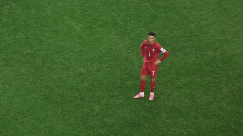 كريستيانو رونالدو يرتدي زي منتخب البرتغال الأحمر يقف بمفرده على أرضية الملعب الأخضر خلال مباراة دولية.