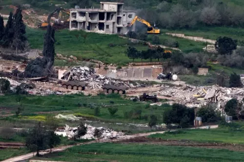 تظهر الصورة عمليات هدم لأحد المباني في منطقة حدودية لبنانية، حيث تعمل جرافات إسرائيلية على إزالة الأنقاض وسط مشهد من الدمار.