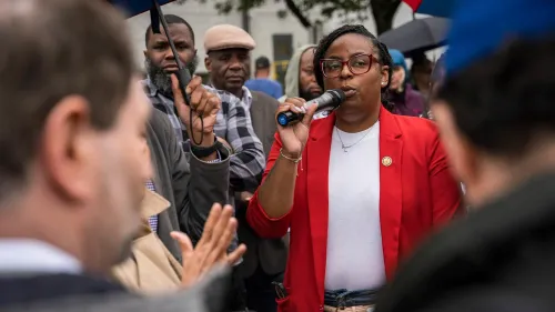 النائبة الديمقراطية لامونيكا مكايفر تتحدث في تجمع حاشد، محاطة بمؤيدين، وسط أجواء مشحونة بعد اتهامات بالاعتداء على موظفي الأمن.