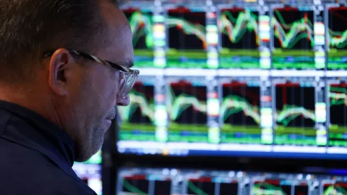 تاجر يتابع تحركات الأسهم على شاشات متعددة، في ظل تراجع السوق الأمريكي بسبب تهديدات ترامب بفرض رسوم جديدة.