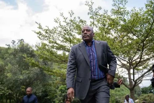 جوزيف كابيلا، الرئيس السابق لجمهورية الكونغو الديمقراطية، يسير في منطقة طبيعية، وسط أشجار، بعد صدور حكم بالإعدام غيابيًا ضده.