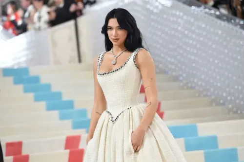 دوا ليبا ترتدي فستان شانيل كريمي عتيق في حفل ميت غالا 2023، مع جيوب واسعة تبرز أهمية الجيوب في الملابس النسائية.