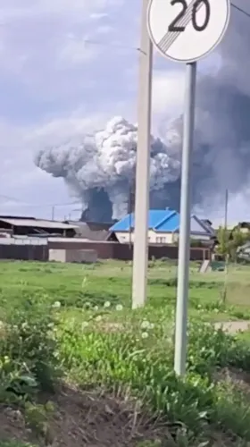 دخان كثيف يتصاعد من موقع انفجار في روسيا، مع وجود لافتة مرورية في المقدمة، مما يعكس تصاعد التوترات العسكرية في المنطقة.