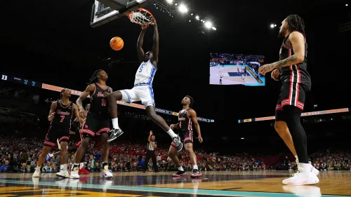 يظهر لاعب كرة السلة خامان مالواش من فريق ديوك وهو يسجل نقطة خلال مباراة، مع لاعبين آخرين في الخلفية.