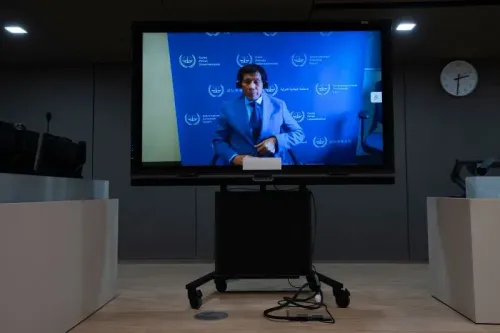 دوتيرتي يظهر عبر شاشة كبيرة في محكمة لاهاي، مرتديًا بدلة رسمية، وسط خلفية تحمل شعار المحكمة الجنائية الدولية.