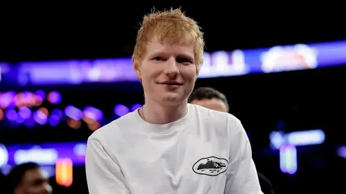 إد شيران مبتسم أثناء حضوره حدث رياضي، يتحدث عن شغفه بمراجعة الأفلام واهتمامه بدعائم السينما.