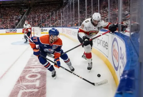 لاعبو هوكي من فريق إدمونتون أويلرز وفريق فلوريدا بانثرز يتنافسون على القرص في نهائي كأس ستانلي، مع جمهور متحمس في الخلفية.