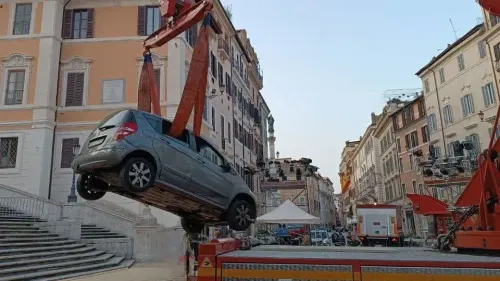 سيارة مرسيدس-بنز رمادية تُرفع بواسطة رافعة خلال عملية إنقاذ بعد أن علقت على السلالم الإسبانية في روما، حيث كان السائق قد ضل الطريق.