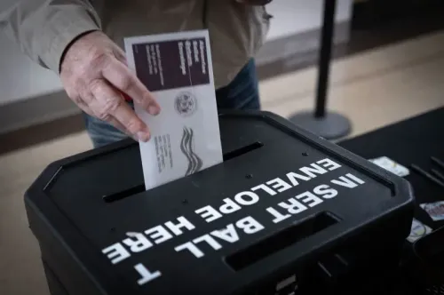 ناخب يضع بطاقته الانتخابية في صندوق الاقتراع، مع وجود علامة واضحة تشير إلى مكان الإدلاء بالأصوات، خلال السباق الانتخابي في ويسكونسن.