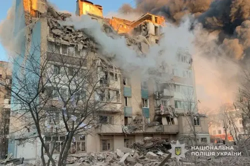 مبنى مدمر في أوكرانيا يتصاعد منه الدخان بعد هجوم روسي، مع آثار الدمار واضحة على الواجهة، مما يعكس تأثير الحرب المستمر.