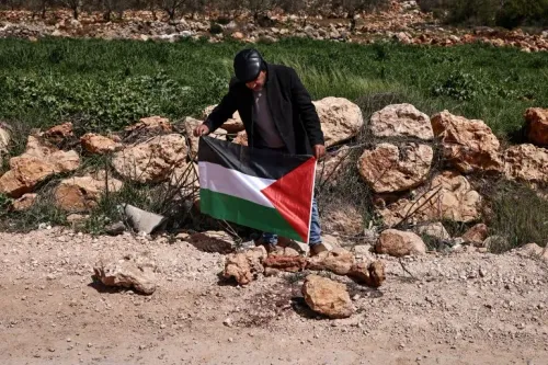 رجل يحمل علم فلسطين قرب موقع بناء في الضفة الغربية، في سياق احتجاجات على توسع المستوطنات الإسرائيلية ومشروع E1 المثير للجدل.