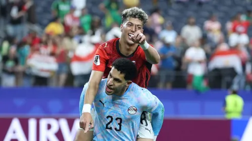 لاعبان من الأهلي يحتفلان بهدف في مباراة كرة قدم، مع تركيز على اللاعبين المصريين وسط أجواء حماسية في الملعب.