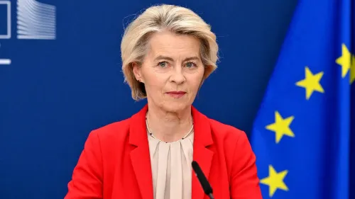 رئيسة المفوضية الأوروبية أورسولا فون دير لاين تتحدث في مؤتمر صحفي حول العقوبات الجديدة ضد روسيا، مع العلم الأزرق للاتحاد الأوروبي خلفها.