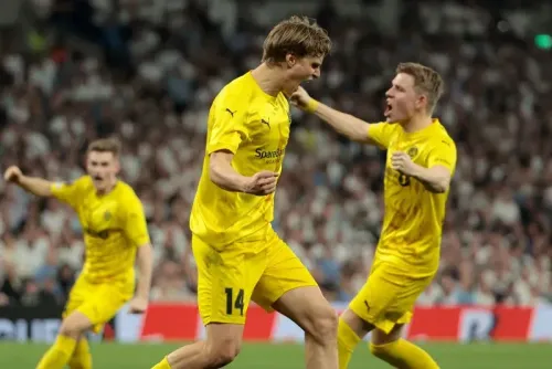 احتفال لاعبي بودو/غليمت بعد تسجيل هدفهم في مباراة نصف نهائي الدوري الأوروبي ضد توتنهام، حيث ارتدوا قمصانهم الصفراء وسط أجواء حماسية.