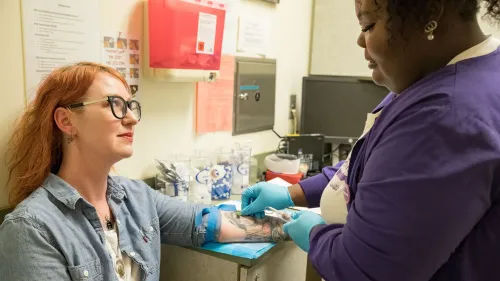 امرأة تتلقى مساعدة طبية أثناء زيارة لعيادة إجهاض، مع التركيز على تفاعلها مع مقدمة الرعاية.