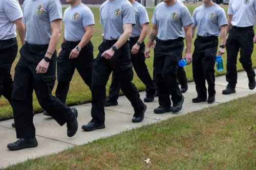 مجموعة من المارشالات الجوية الفيدرالية يرتدون زيًا موحدًا، يسيرون في صف واحد، مما يعكس جهودهم في تأمين رحلات الترحيل.