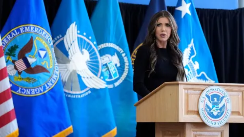 وزيرة الأمن الداخلي كريستي نويم تتحدث في مؤتمر صحفي، مع وجود أعلام الوكالة الفيدرالية لإدارة الطوارئ في الخلفية.