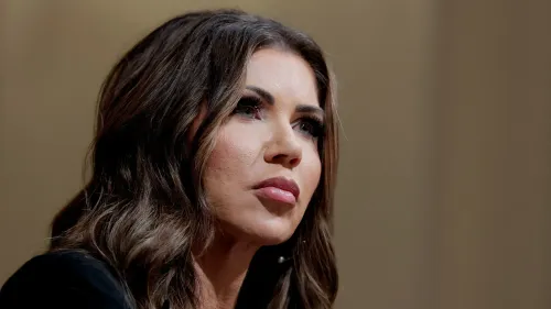 وزيرة الأمن الداخلي كريستي نويم تتحدث بجدية، مع التركيز على ملامح وجهها، في سياق قضية تهديد الرئيس ترامب.